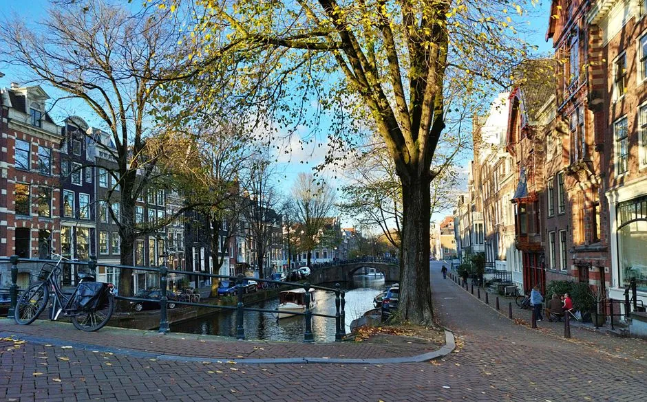 A quiet Amsterdam canal street with parked bicycles and canal houses in autumn
