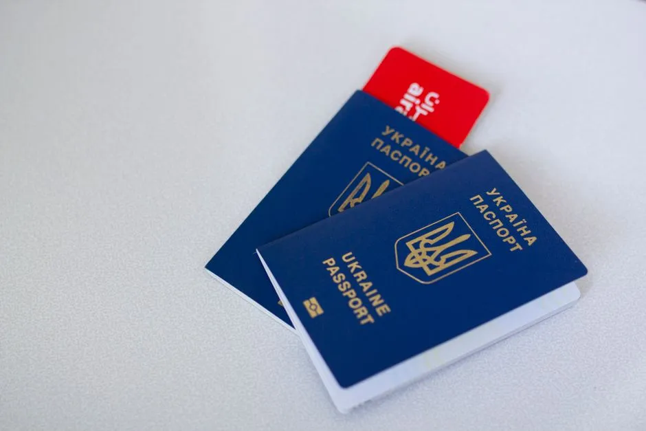 Two passports and a boarding pass style card fanned out on a light tabletop