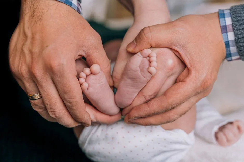 A parent's hands cradling a newborn baby's bare feet