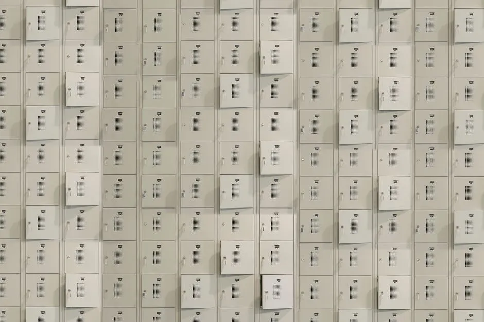 A wall of identical self-service parcel lockers seen head-on, rows of closed metal compartment doors, no people, text, or logos visible