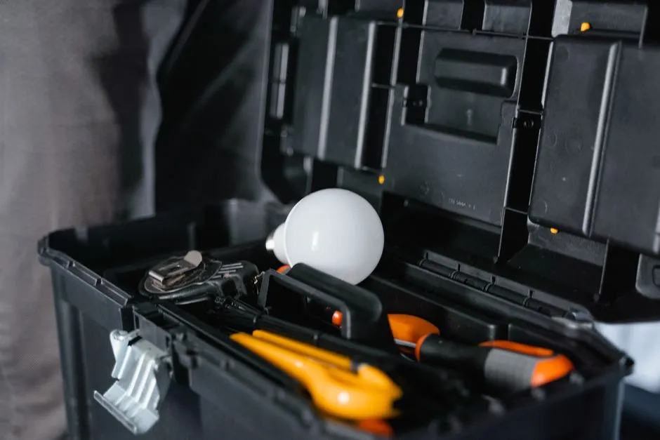 Close-up of an open toolbox with a wrench, pliers, and a work light packed inside, no people, text, or logos visible