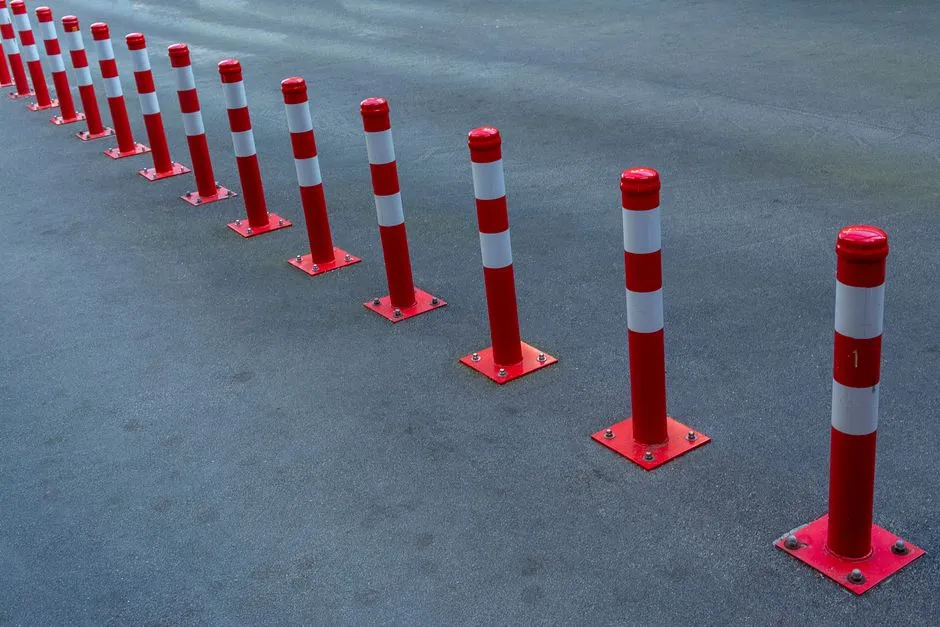A row of red and white traffic bollards blocking a stretch of road, no vehicles, signage, or people visible