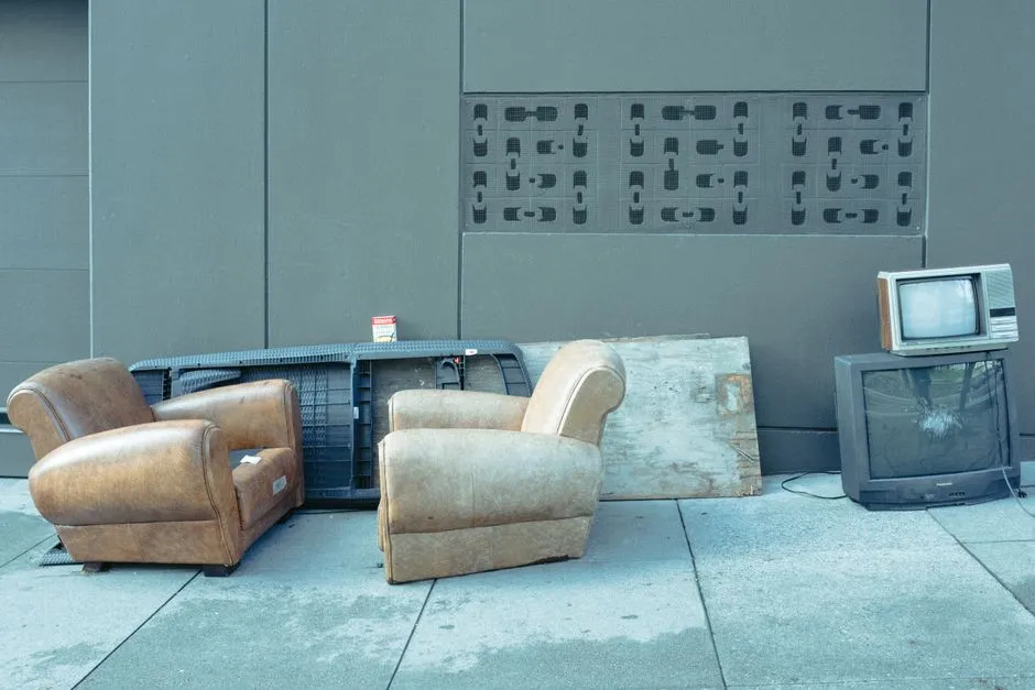 Discarded furniture and household items piled at a curbside for bulky waste collection